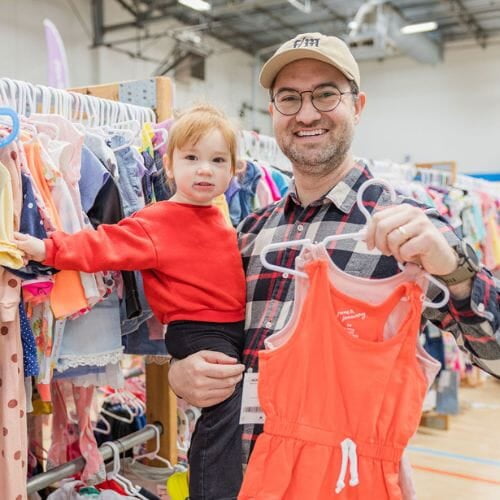 A mother and daughter stand side by side in their masks as they shop their local JBF sale.